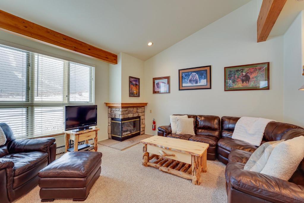 a living room with leather furniture and a flat screen tv at East Village Duplex at Copper Mountain Resort! in Frisco