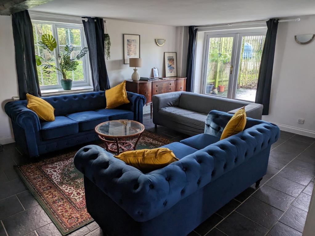 - un salon avec des canapés bleus et des oreillers jaunes dans l'établissement Spacious Country Cottage with 3 Double Bedrooms, à East Dereham