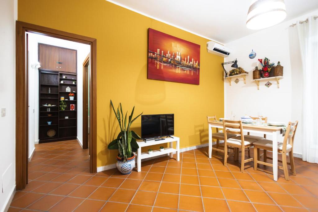 a dining room with a table and a television at Ai Bottonai Casa 23 in Palermo