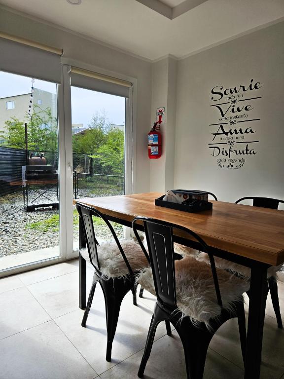 a dining room with a wooden table and chairs at Monte Fueguino in Ushuaia