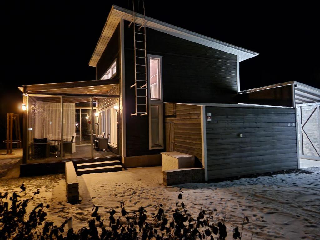 un grupo de pájaros parados fuera de una casa por la noche en Peuhuntie As 15 en Oulu