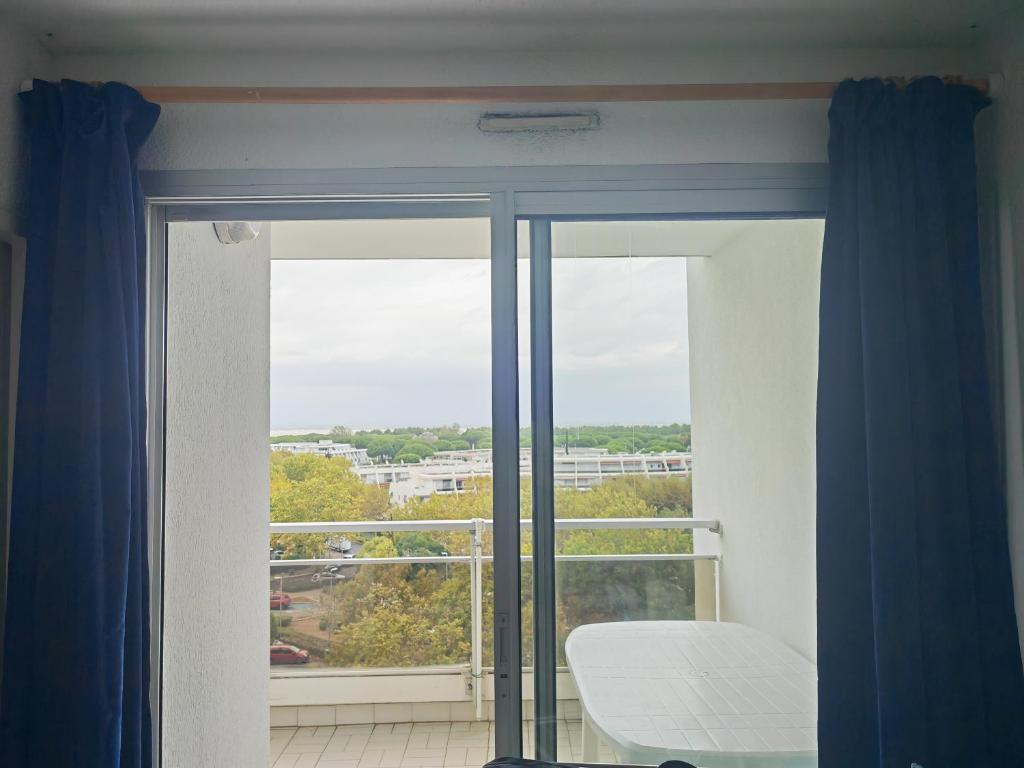 Cette chambre dispose d'une fenêtre offrant une vue sur un bâtiment. dans l'établissement LA GRANDE MOTTE LE COUCHANT STUDIO cabine, à La Grande Motte