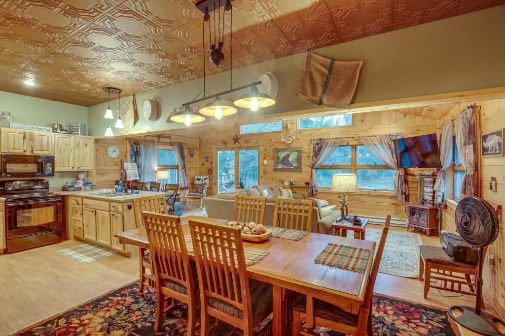 a kitchen and living room with a table and chairs at 40-Acre, Off-Grid Wakefield Retreat with Gas Grill! in Wakefield