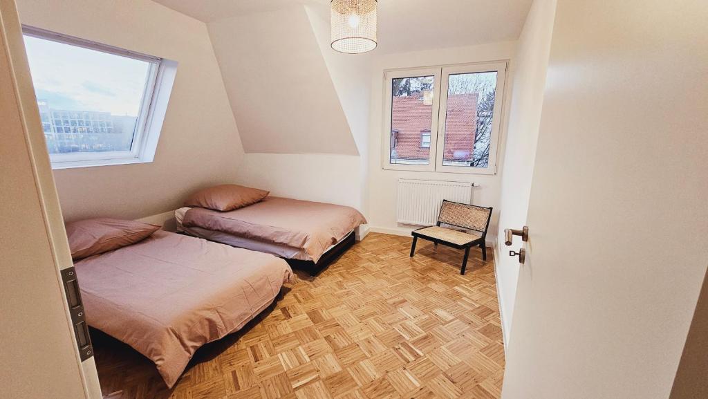 two beds in a room with two windows at Luxus Penthouse Nähe Frankfurt in Bad Homburg vor der Höhe