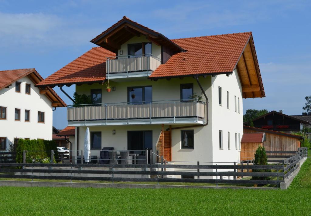 a large white house with a red roof at Ferienwohnung Anner Gstadt in Gstadt am Chiemsee
