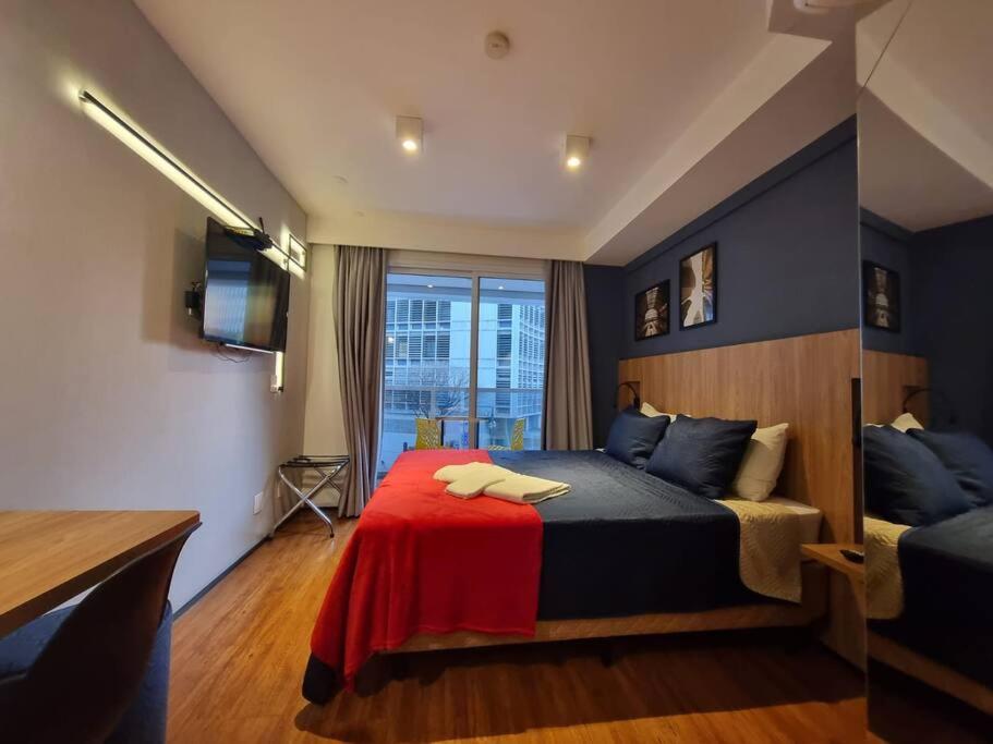 ein Schlafzimmer mit einem Bett mit einer roten Decke in der Unterkunft Lindo Studio Consolação, 312 in São Paulo