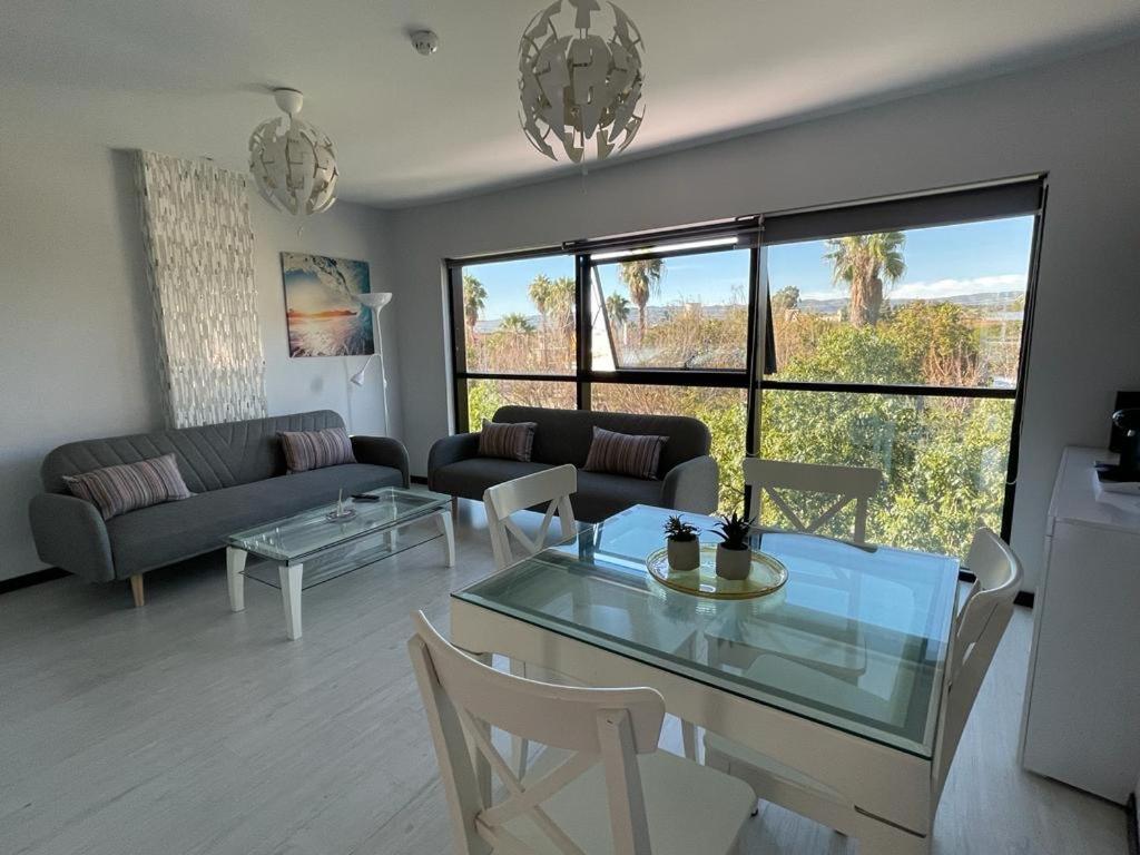 a living room with a glass table and a couch at TECNOCORDOBA II aparcamiento privado gratuito y piscina in Córdoba