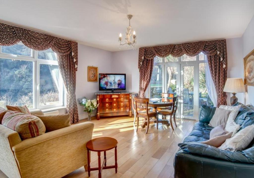 een woonkamer met een bank en een tafel bij Kilmorie Lodge in Torquay