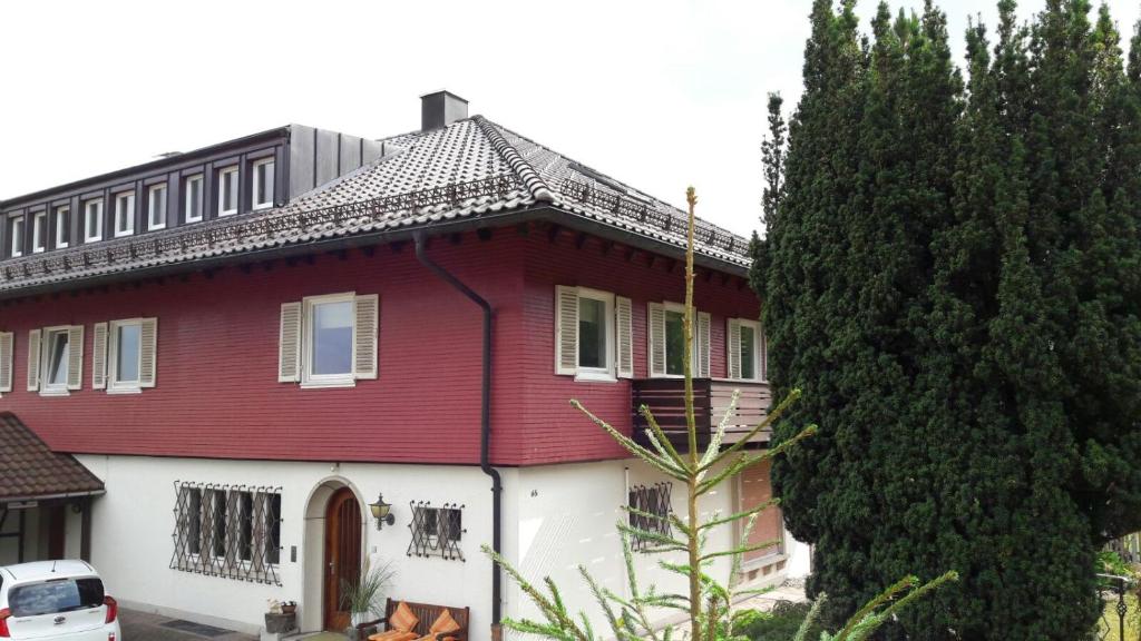 una casa roja y blanca con un árbol en Landhaus Bukenberger en Freudenstadt