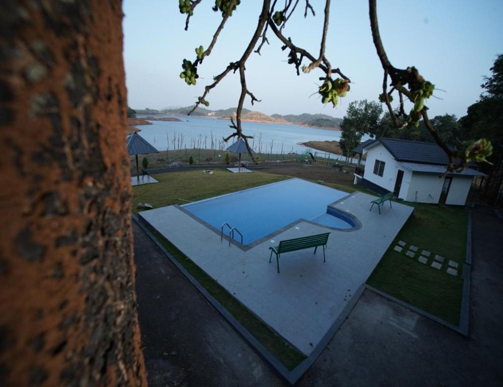 einen Blick über einen Pool mit einer Bank in der Unterkunft Misty Dam Wayanad Premium Resort With Banasura Dam View in Padinjarathara