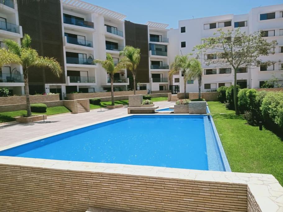 una piscina frente a un edificio de apartamentos en sublime studio côté balnéaire, en Agadir