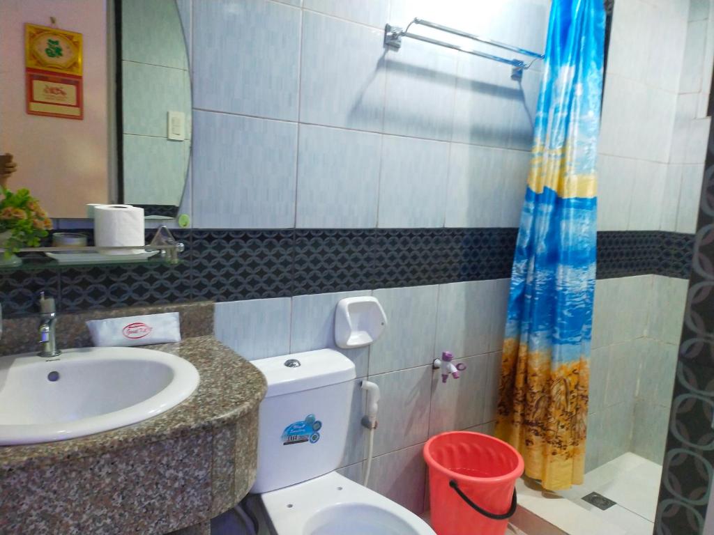a bathroom with a sink and a toilet and a mirror at Cozy Condo Unit w/ FREE WIFI&Netflix-Pay Parking in Antipolo