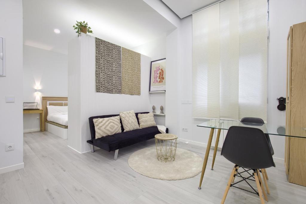uma sala de estar com uma mesa de vidro e um sofá em Charming Madrid el Carmen em Madri