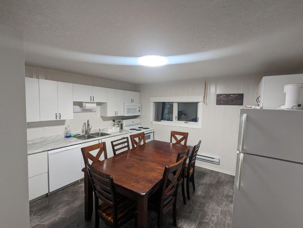 eine Küche mit einem Holztisch und einem Kühlschrank in der Unterkunft Wildgoose Accommodations in Reston