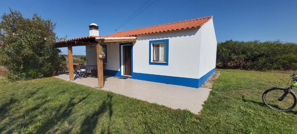 una pequeña casa blanca y azul en un campo en Monte Gaia, en Cavaleiro