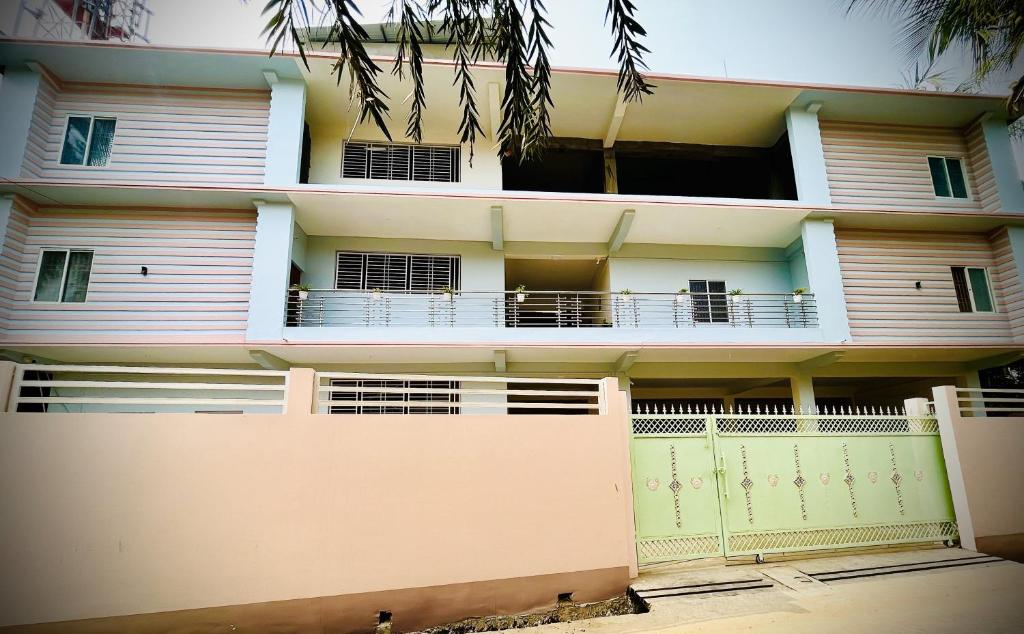 ein Apartmenthaus mit einem Zaun davor in der Unterkunft Queen's Residency in Guwahati