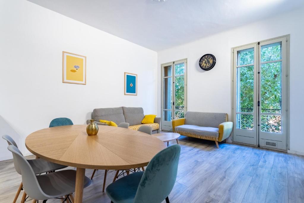 een woonkamer met een tafel en stoelen bij L'Haussmannien - Appartement standing - hypercentre in Toulon