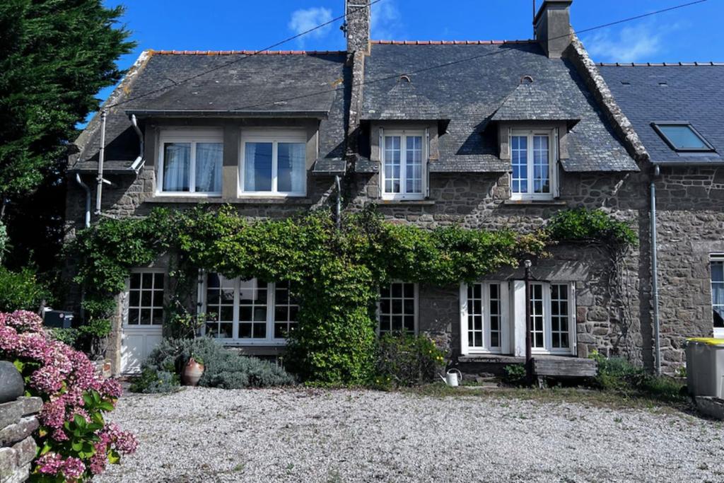 a stone house with ivy on the front of it at Rare pearl with garden facing the sea in Saint-Coulomb