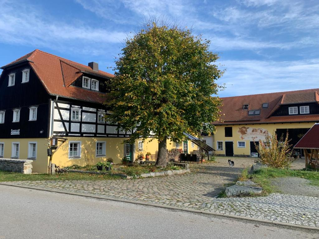 a building with a tree in the middle of a street at SPREEHOF Göbeln in Großdubrau