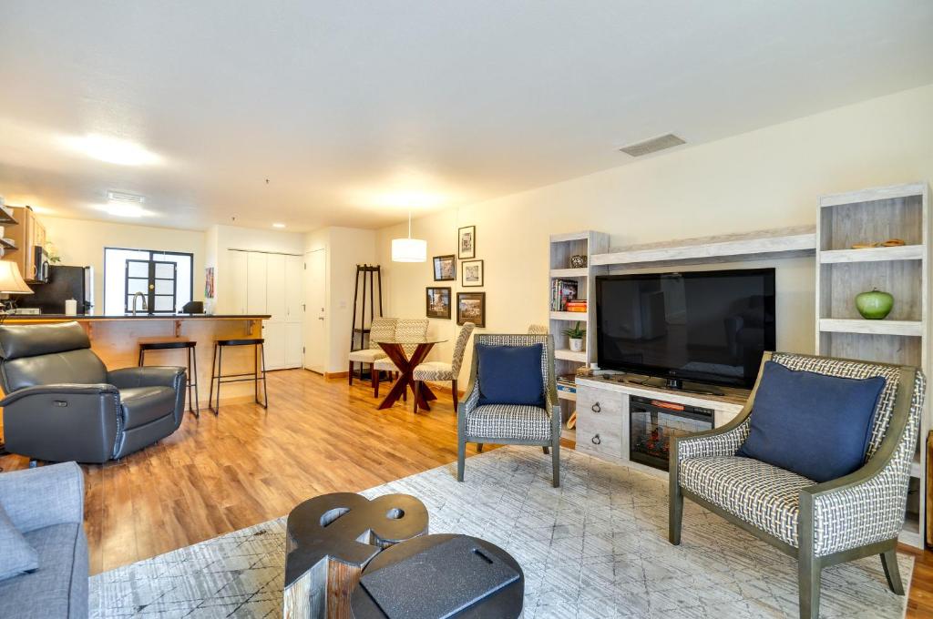 a living room with a flat screen tv and chairs at Portland Condo with Hot Tub Access, Near Downtown! in Portland