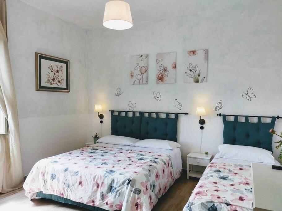 a bedroom with two beds and paintings on the wall at Casa di Campagna in Ronciglione