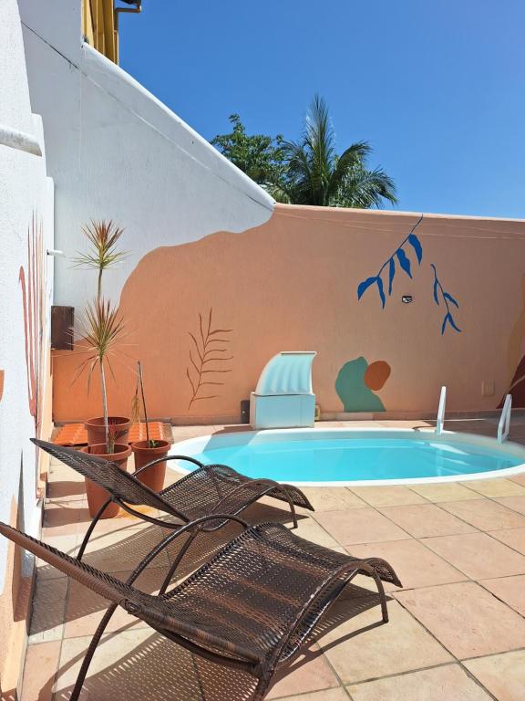 a swimming pool with a chair next to a wall at D'Ajuda Inn in Arraial d'Ajuda