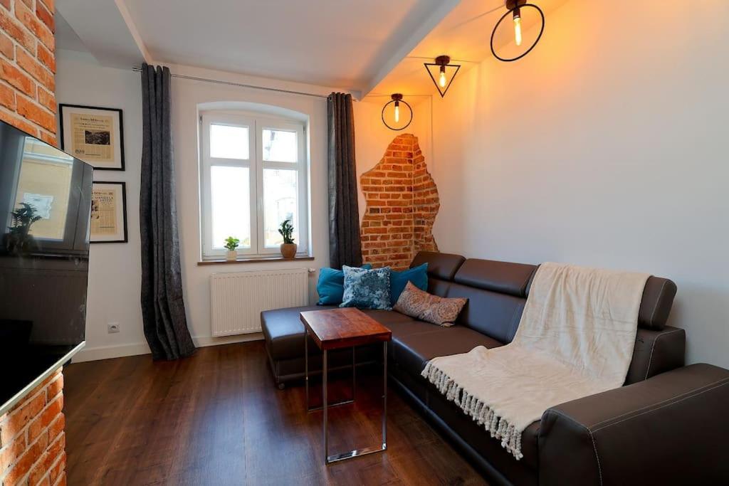 un soggiorno con divano e finestra di Przytulnie z The GG Apartments a Poznań