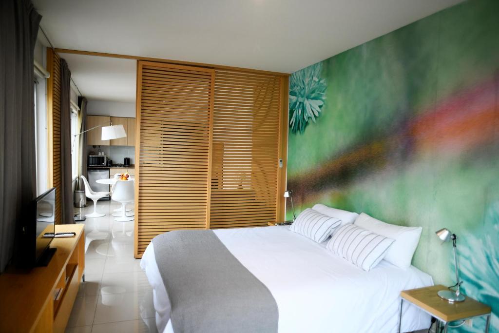 a bedroom with a white bed and a green wall at Dream Studios BA in Buenos Aires