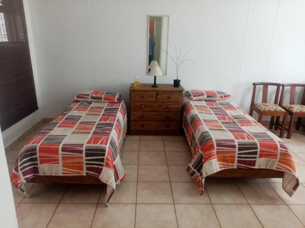 two beds sitting next to each other in a bedroom at Happy days in Amanzimtoti