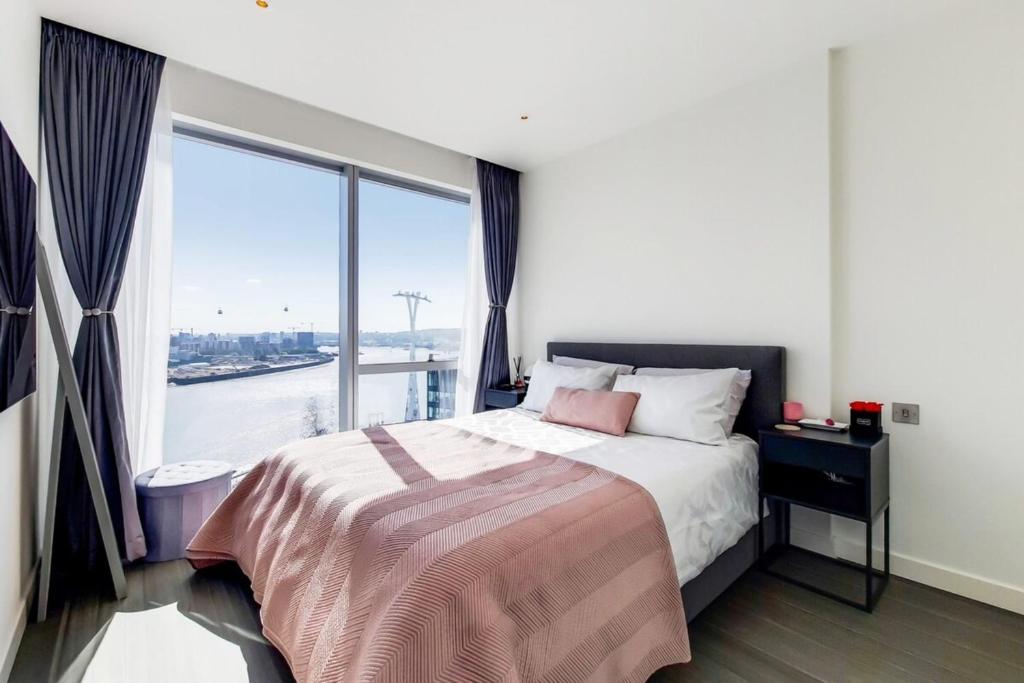 1 dormitorio con cama y ventana grande en Ravishing 1BD Flat - 2 minute walk from the O2!, en Londres