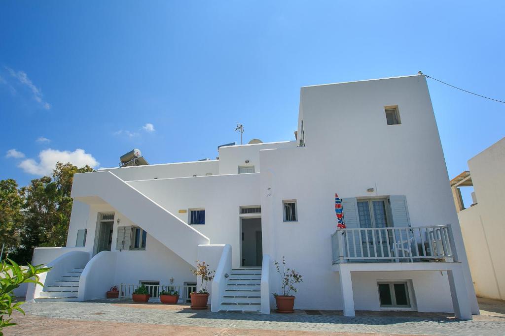 a white building with stairs and a balcony at Ampeli Apartments in Parikia