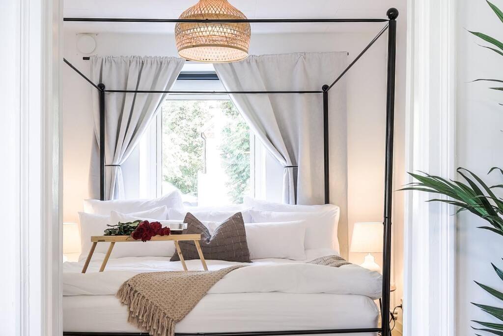a bedroom with a canopy bed with a window at Fully Equipped Cosy Flat Close to Malmö&Copenhagen in Vellinge