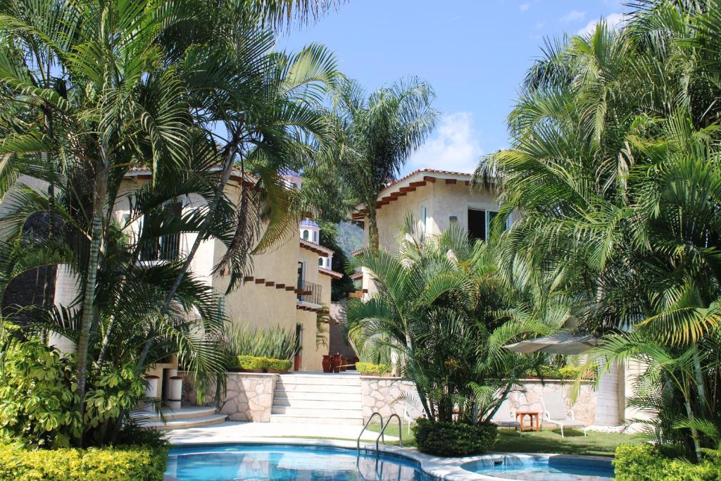 a building with palm trees and a swimming pool at Nequi Hotel Boutique in Tepoztlán