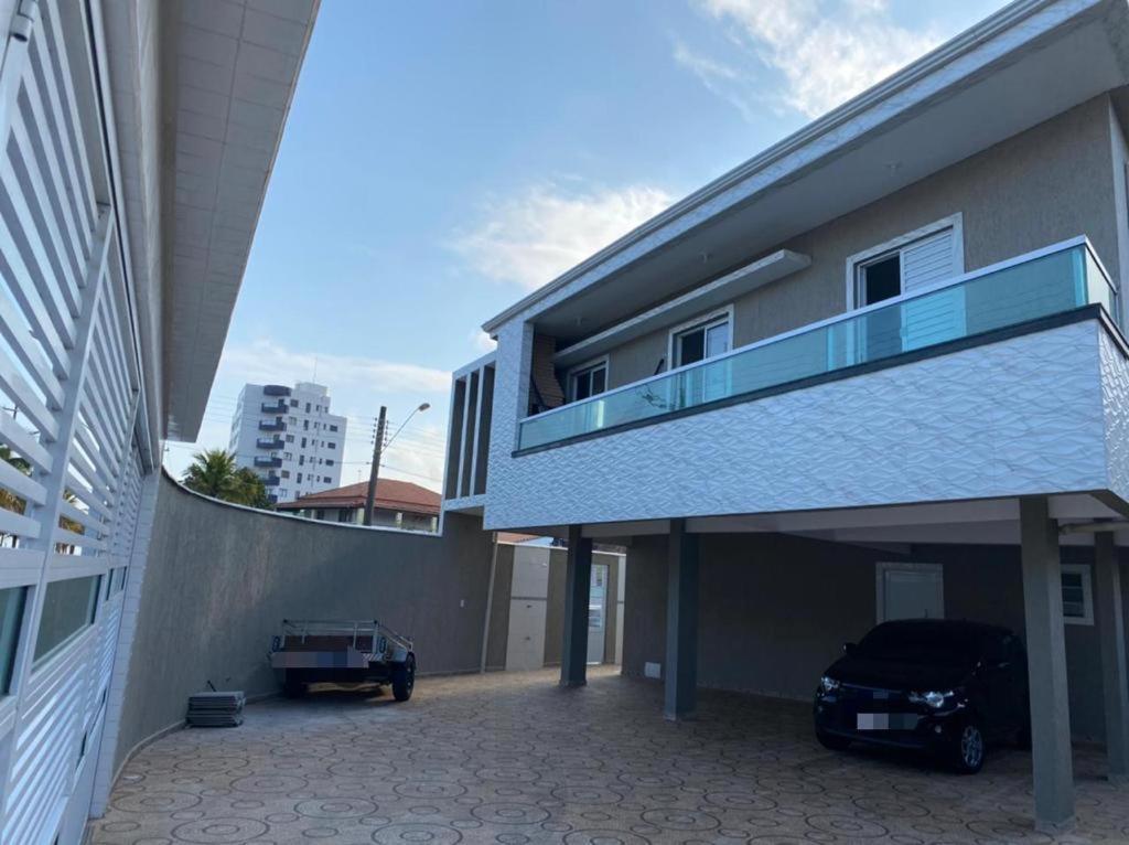 un bâtiment avec une voiture garée dans une allée dans l'établissement Casa Condomínio FRENTE PARA O MAR, à Praia Grande
