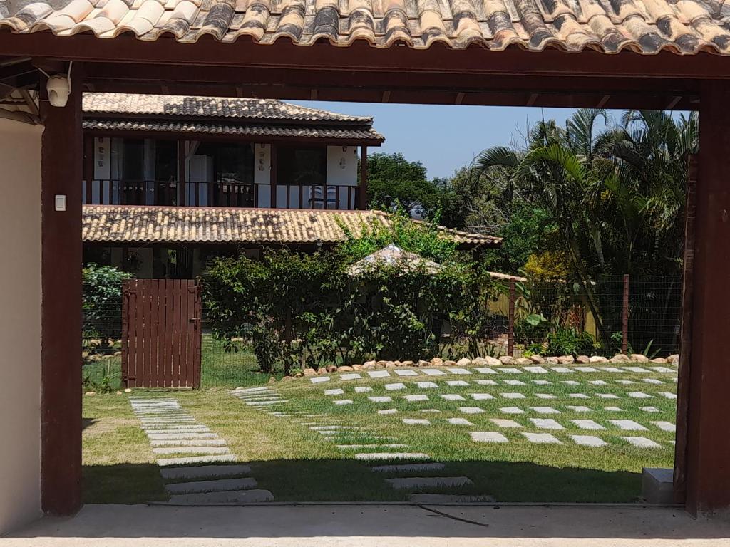 una puerta abierta a un patio con un edificio en Jardim das Emerências - Búzios, en Búzios