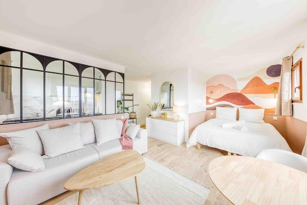 ein Wohnzimmer mit einem Sofa und einem Bett in der Unterkunft Le Boudoir, studio chic Aéroport d’Orly in Athis-Mons