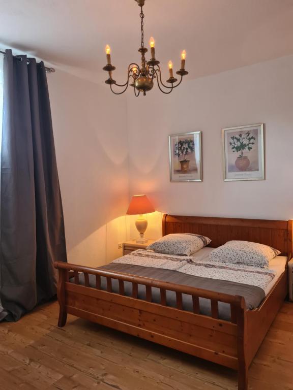 een slaapkamer met een bed en een kroonluchter bij Ferienwohnung besonderer Art in Windeck