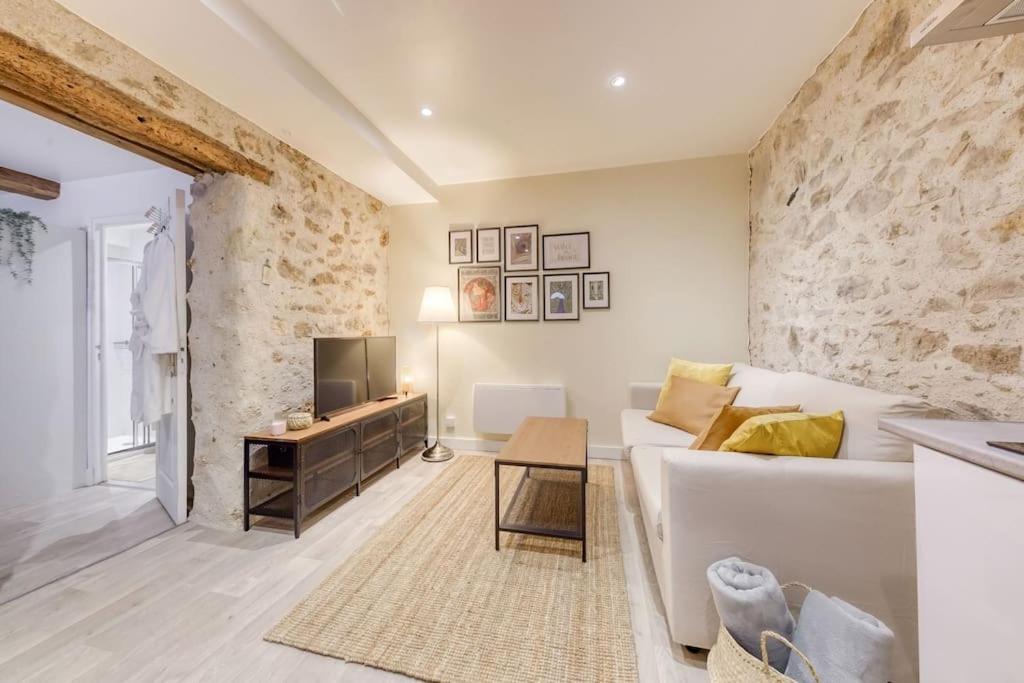 - un salon avec un canapé blanc et une télévision dans l'établissement Le Refuge, T2 élégant Aéroport d'Orly, à Athis-Mons