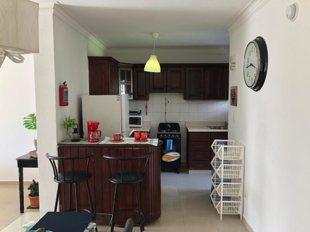 a kitchen with a counter and a clock on the wall at Adorable Santo Domingo in Santo Domingo