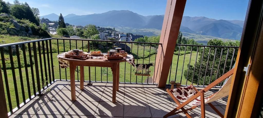 una mesa en un balcón con vistas a las montañas en APPART 2 chambres DECO CHALET & VUE IMPRENABLE MONTAGNE en Font Romeu Odeillo Via