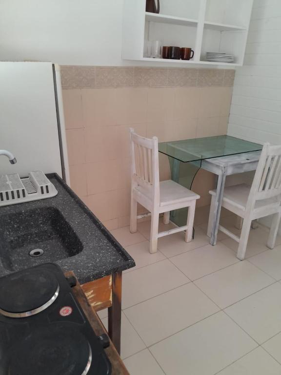 a kitchen with a table and a table and chairs at Itapira Flats - Apto 7 in Imbituba
