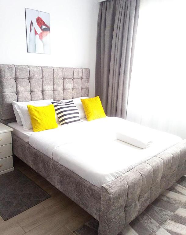 a large bed with yellow pillows in a bedroom at POLAR HOMES in Syokimau