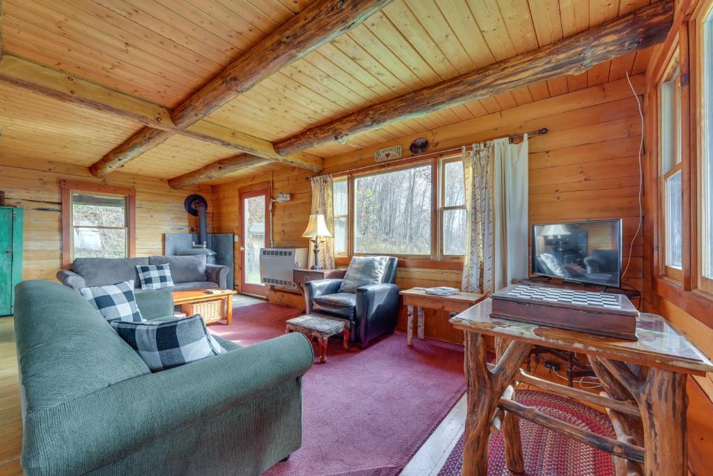 a living room with a couch and a laptop on a table at Remote Escape Vermont Cabin with Mountaintop Views! 