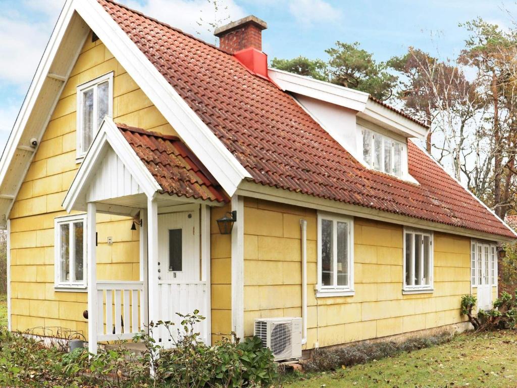 ein gelbes Haus mit rotem Dach in der Unterkunft Holiday home LAHOLM IX in Laholm