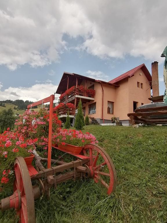 a wooden cart filled with flowers in front of a house at Cabana Gabriel Bucovina in Vatra Dornei