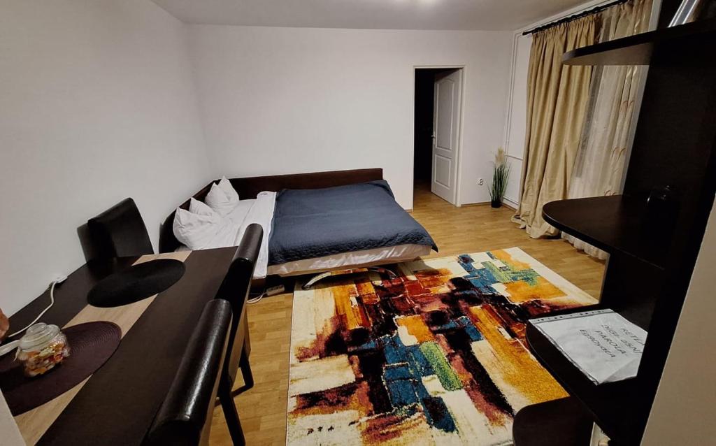 um quarto com uma cama e uma mesa com um tapete em A&M em Târgu-Mureş