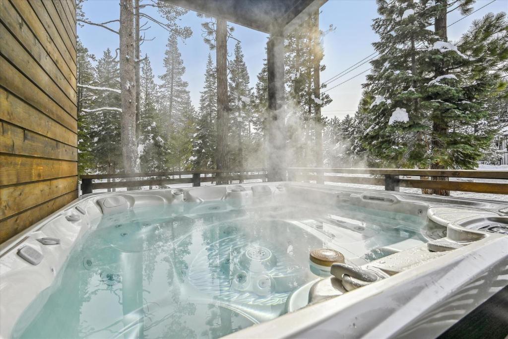 a hot tub on a deck with trees in the background at NEW LISTING! Diamond Run at Palisades Tahoe - Pet Friendly and NEW hot tub! in Olympic Valley