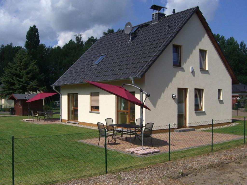 een huis met een tafel en stoelen ervoor bij Karlshagen, Ferienhaus am Hasenwinkel in Ostseebad Karlshagen