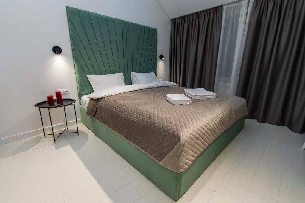 a bedroom with a large bed with a green headboard at MYFREEDOM Premium Apartments near Khreshchatyk in Kyiv