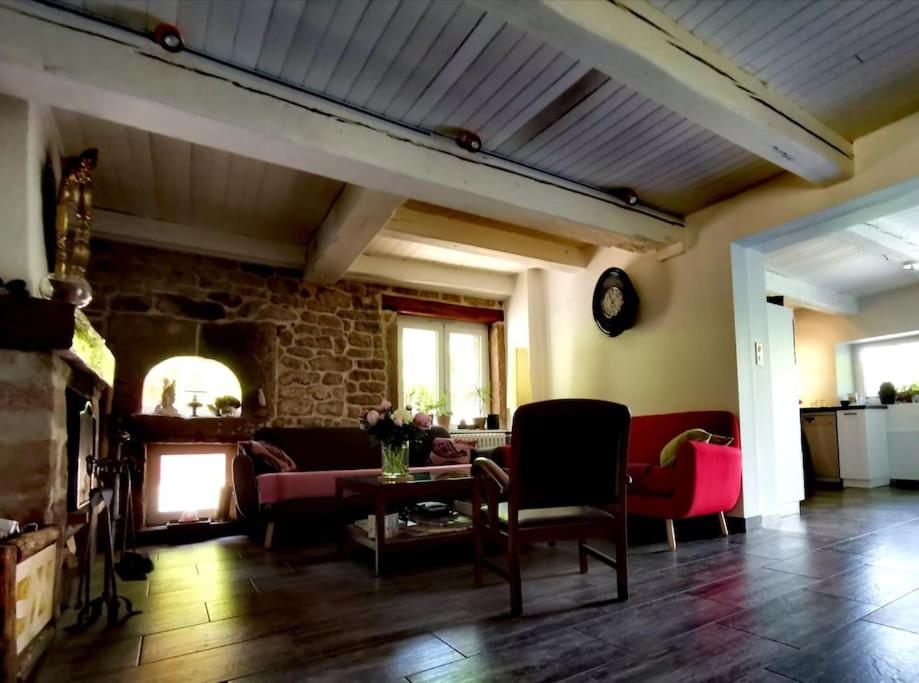 a living room with a couch and a fireplace at La Maison Thébaïde in Mortagne